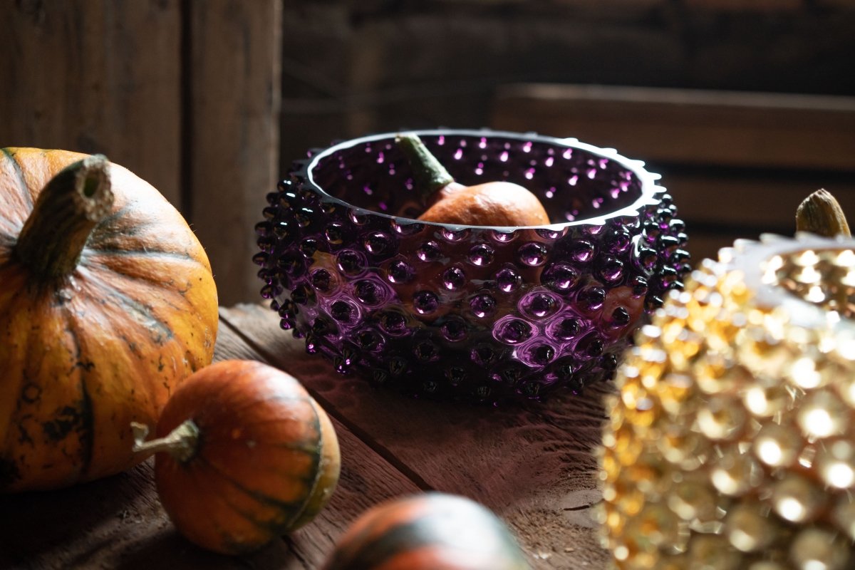 Violet Hobnail Bowlon on a wooden table surrounded by pumpkins