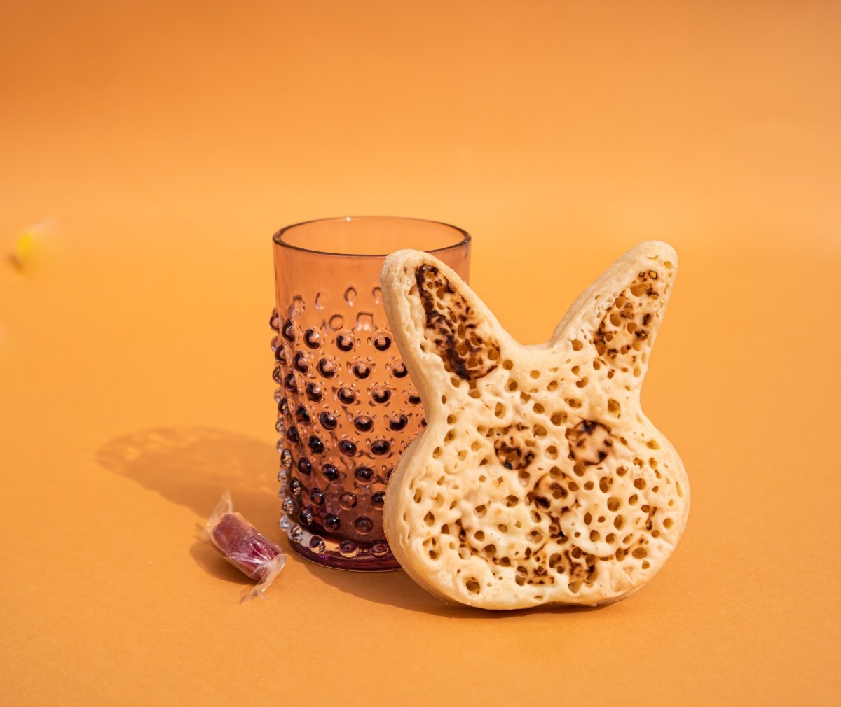 Underlay Violet Hobnail Tumblers on an orange floor surrounded by sweets
