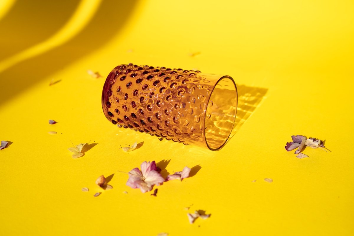 Underlay Violet Hobnail Tumblers on a yellow ground surrounded by flower petals