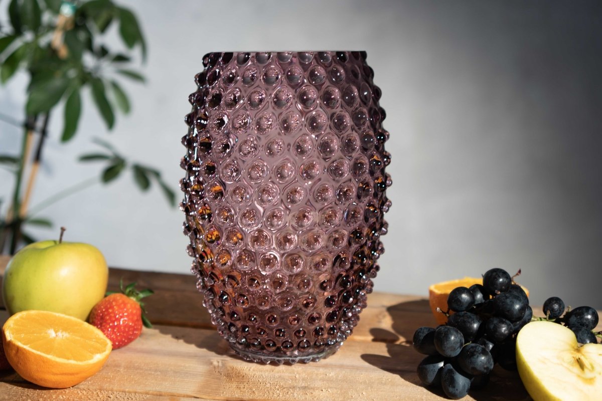 Underlay Violet Egg Hobnail Vase on a wooden table surrounded by various fruits