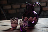 Violet Marika Tumblers on a wooden pallet, with a pitcher from the same collection and a brick base 